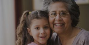 Hispanic grandmother hugging granddaughter